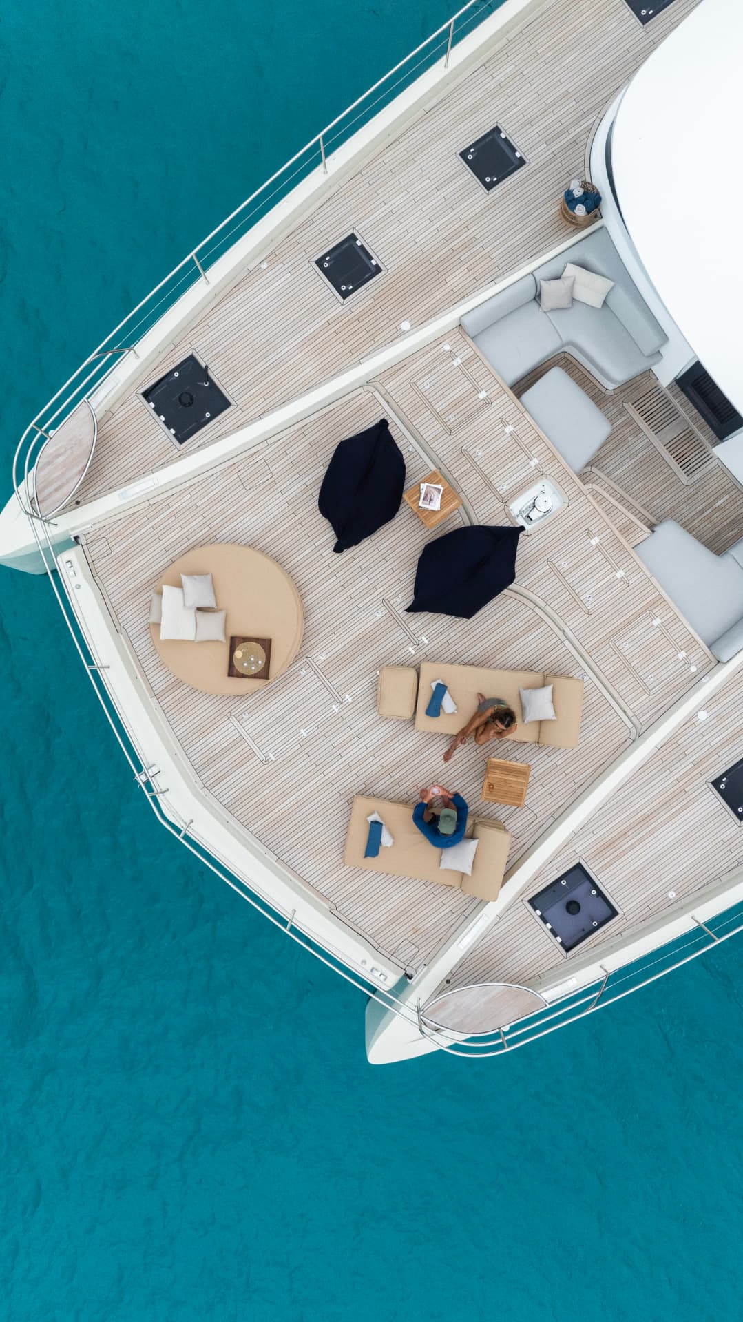 Aerial view of a yacht foredeck with guests relaxing at anchor