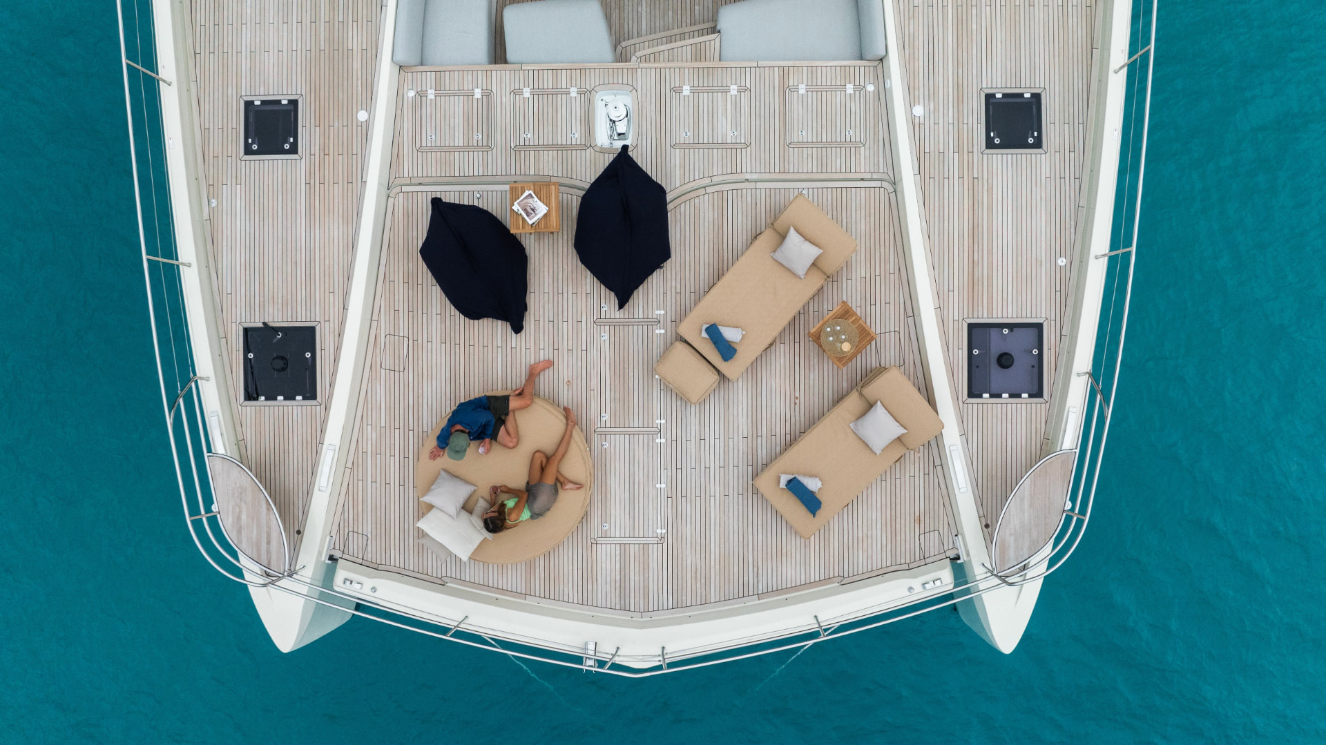 Aerial view of a yacht foredeck with guests relaxing at anchor